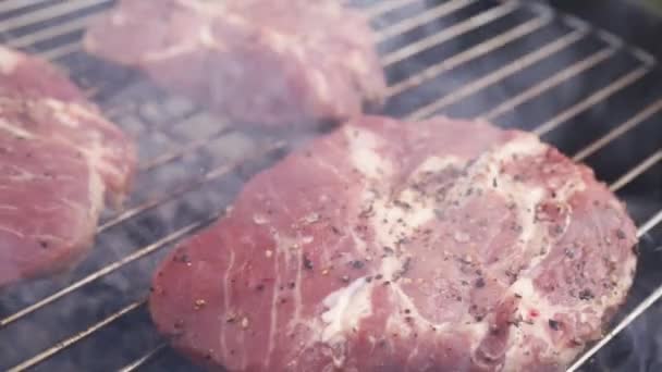 Kochen saftige rohe Fleischsteaks auf dem Grill — Stockvideo