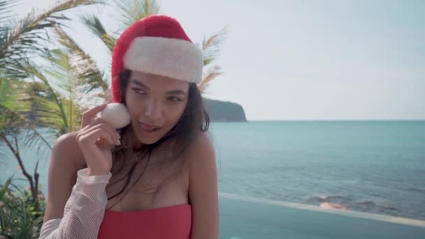 Mujer sexy joven cerca de la piscina en Santa sombrero celebrando Año Nuevo y Navidad — Vídeo de stock