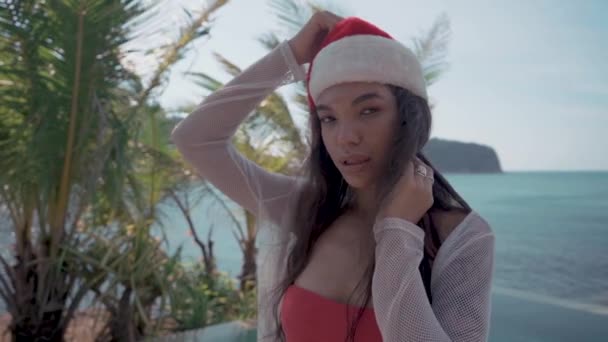 年轻的性感的妇女在游泳池附近在圣诞老人帽子庆祝新年和圣诞节 — 图库视频影像