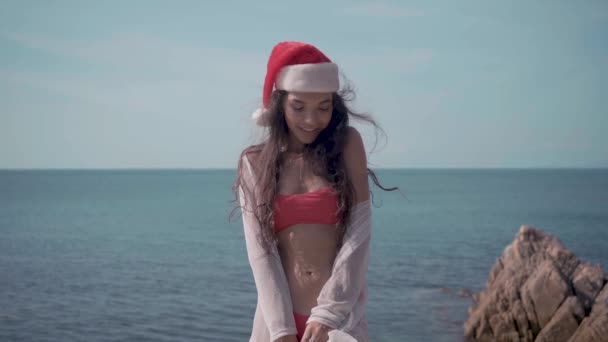 年轻的性感的妇女在游泳池附近在圣诞老人帽子庆祝新年和圣诞节 — 图库视频影像