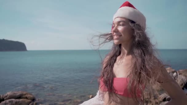 Young sexy woman near the swimming pool in Santa Claus hat celebrating New Year and Christmas on the luxury villa in slow motion