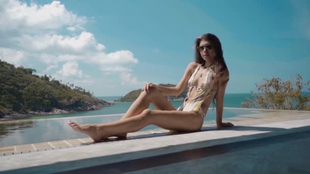 Dolly strzał piękna kobieta na skraju basenu na luksusowej willi — Wideo stockowe