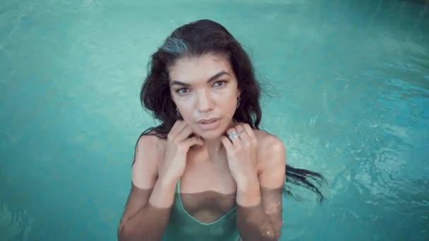 Jovem mulher glamour de biquíni de pé na borda da piscina na villa e olhando para a câmera — Vídeo de Stock
