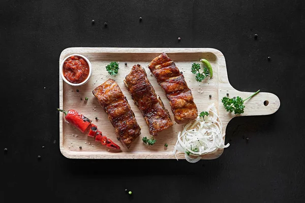 Barbekü domuz kaburga biber biber, sos ve soğan kesme tahtası üzerinde görünümü top