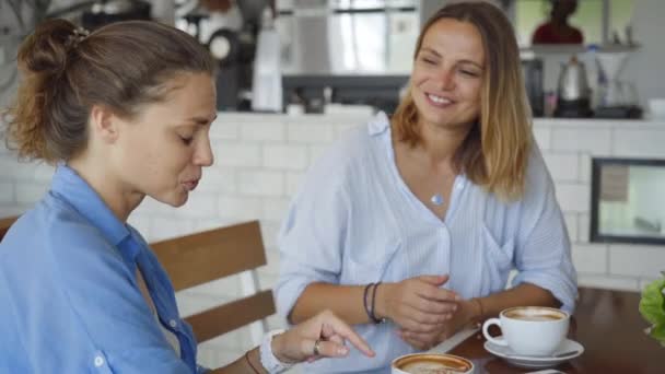 Lesbisk par med datum i café. Vackra flickor prata och dricka kaffe. — Stockvideo