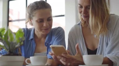 Kadın tarihi kafede. Cep telefonu üzerinde heyecan verici bir şey bir paylaşım