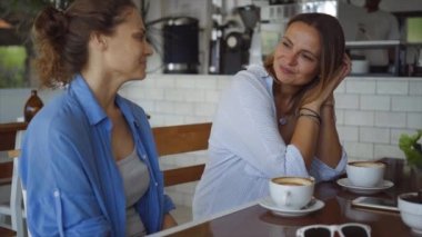 Lezbiyen çift kafede sohbet. Dedikodu ve kahve içme iki güzel kadın