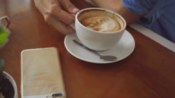Дві жінки ділять каву в кафе, крупним планом знімають на чашці кави — стокове відео