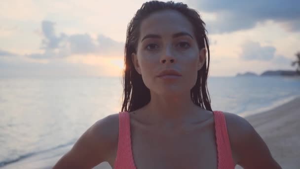 Женщина на пляже в бикини чувственно бежит руками по лицу и волосам — стоковое видео