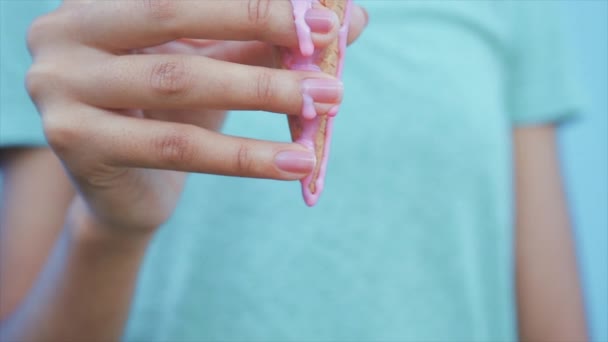 Νεαρό κορίτσι Αφρο τρώει ροζ λιώνει το παγωτό σε φόντο μπλε τοίχο — Αρχείο Βίντεο