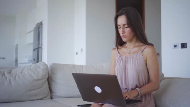 Молода жінка працює на комп'ютері з малюванням майданчика на освітленій віллі — стокове відео