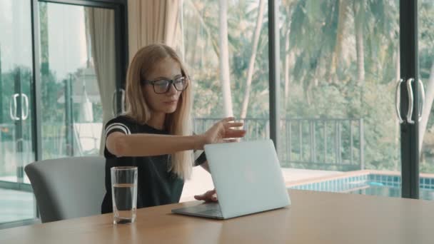 Женщина открывает ноутбук на столе дома и начинает печатать в течение дня. внештатная концепция — стоковое видео