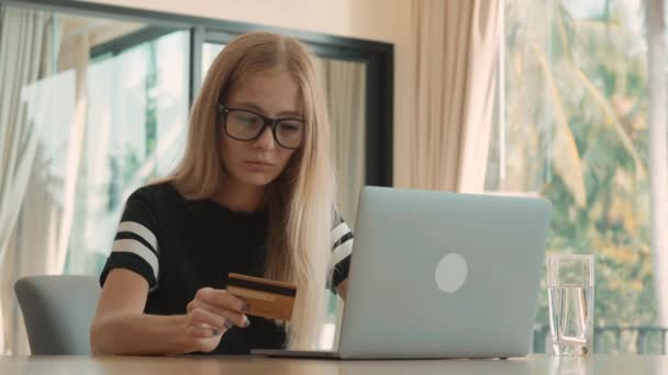 Женщина вносит данные своей кредитной карты в компьютер дома в течение дня — стоковое видео