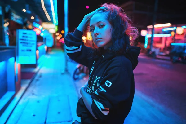 Neon yakın yukarı genç kadın portre giymek hoodie. gece şehir sokak shot