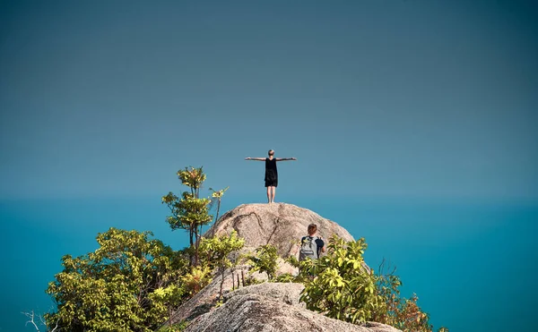 女孩站在山顶上，在蓝色的海景 — 图库照片