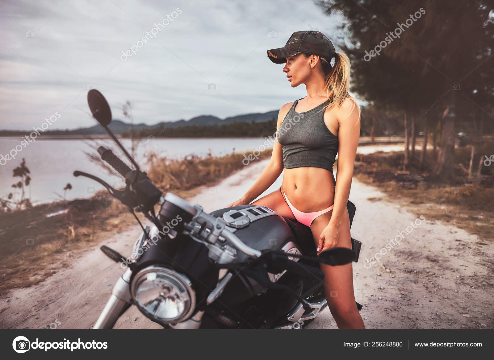 Outdoor lifestyle portrait of young sexy woman in bikini sitting on a  vintage custom motorcycle Stock Photo by ©romablack 256248880