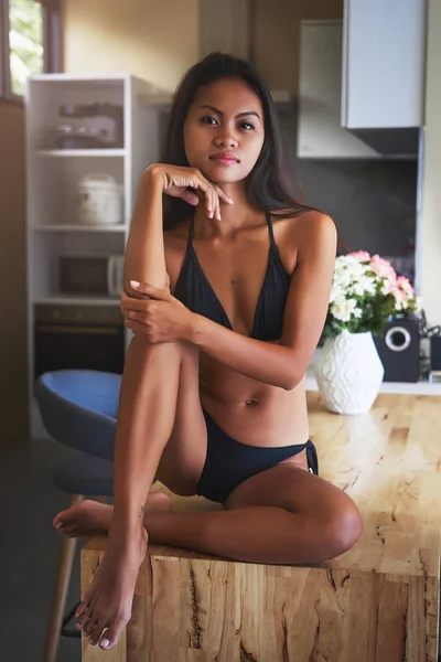 Sexy Asian girl sitting on the table and relax in kitchen at home — Stock Photo, Image