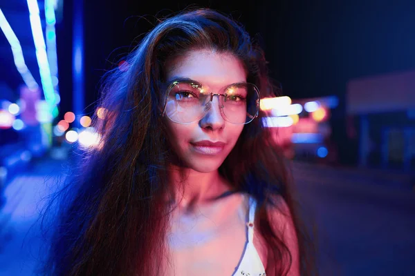 Porträt einer schönen jungen Frau mit Brille in futuristischem Neonlicht — Stockfoto
