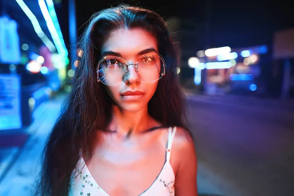 Retrato de uma bela jovem mulher com óculos em luz neon futurista — Fotografia de Stock