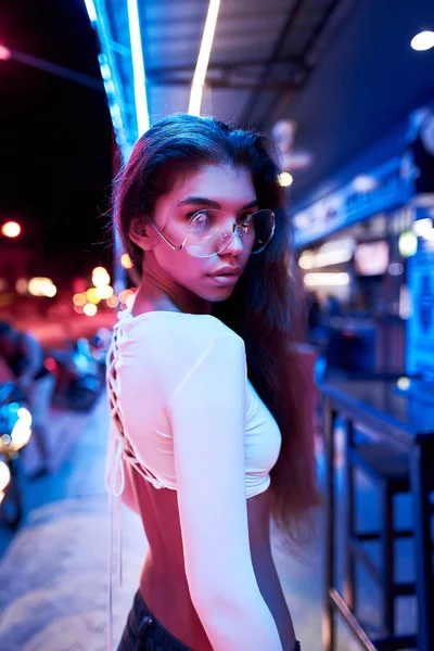 Retrato de uma bela jovem mulher com óculos em luz neon futurista — Fotografia de Stock