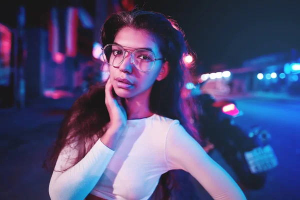 Retrato de uma bela jovem mulher com óculos em luz neon futurista — Fotografia de Stock