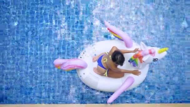 Sexy mujer asiática en bikini relajante en el unicornio en una piscina — Vídeo de stock