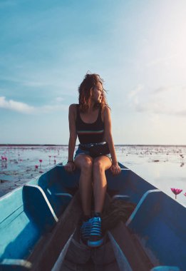 thale noi gölünde tur sırasında genç kadının açık hava portresi mavi teknede oturuyor