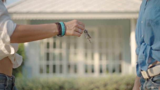 Makelaar die sleutels geeft aan nieuwe eigenaren van onroerend goed. Zomertijd — Stockvideo