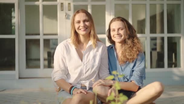 Gelukkig lesbisch paar zittend op de veranda van hun huis — Stockvideo