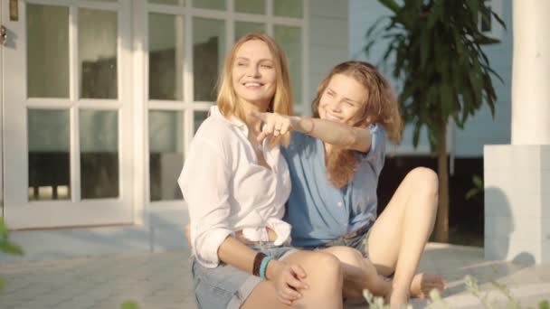 Happy lesbian couple sitting on the porch of their house — Stock Video