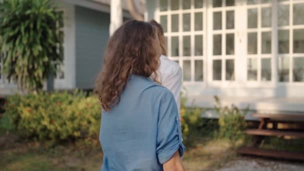 Feliz pareja lesbiana caminando en el patio trasero de su casa — Vídeos de Stock