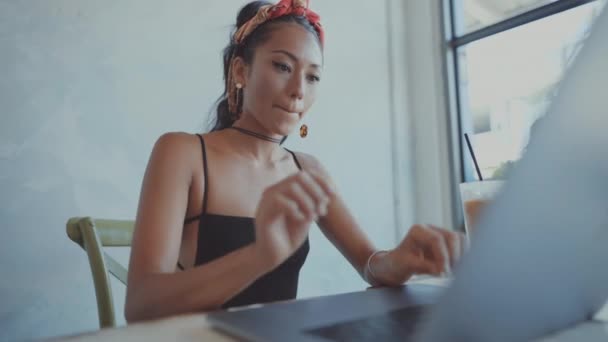 Mujer sonriendo y trabajando en su portátil — Vídeos de Stock