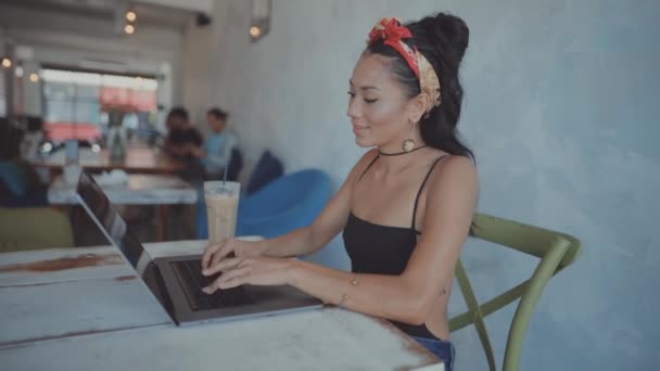 Frau arbeitet in einem Café an ihrem Laptop — Stockvideo