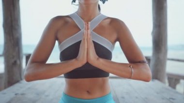 Güzel asyalı kadın meditasyon ve el sembolleri gösteren kamera düz bakar