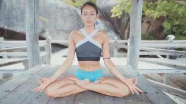 Kadın oturma ve meditasyon ve villa altında iken kameraya düz bakıyor