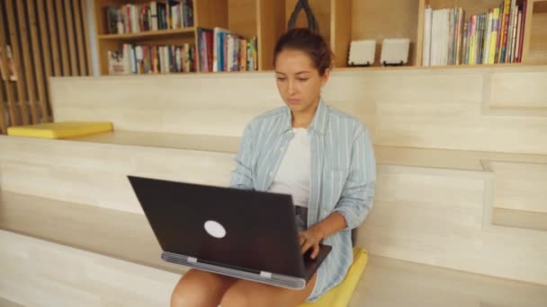 그녀의 무릎에 휴식 그녀의 노트북과 함께 작업 하는 여자 — 비디오