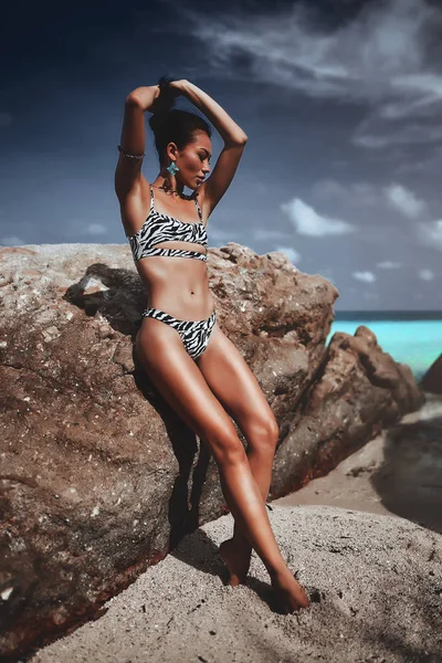 Sexy dziewczyna w zebra kolorowe bikini pozowanie na niebieskim tle morza — Zdjęcie stockowe