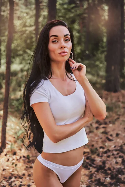 Szexi fekete hajú lány visel fehérnemű álló egy erdőben — Stock Fotó