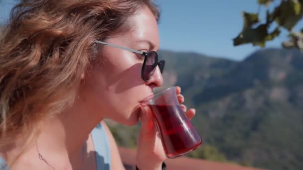 Woman sitting in cafe with beautiful view and drinking traditional turkish tea — 图库视频影像