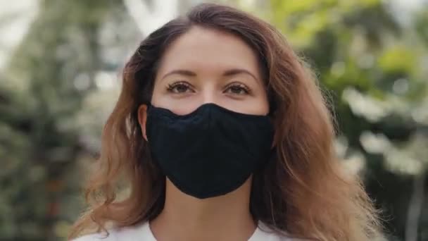 Girando em torno de uma jovem mulher tira sua máscara médica — Vídeo de Stock