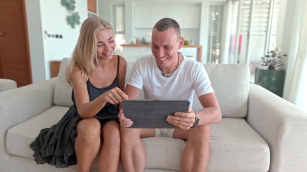 Couple utilisant une tablette et assis sur le canapé — Video