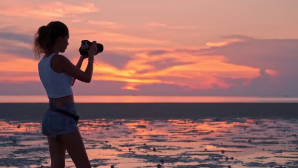 Kvinnan tar bilder av solnedgången på stranden — Stockvideo