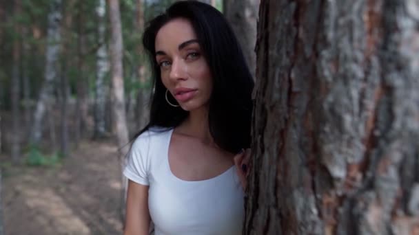 Ormanda bir ağacın yanında duran kadın. — Stok video