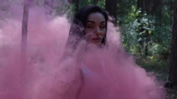 Femeie cu fum roz în picioare într-o pădure — Videoclip de stoc