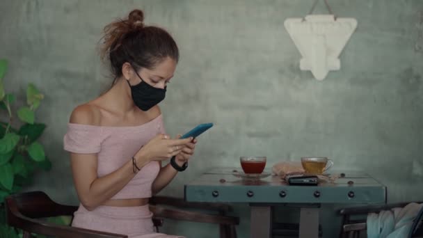Kafede koruyucu maskeli bir kadın — Stok video