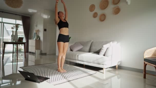 Csinos fiatal nő jógázik otthon a neten. Egészséges életmód koncepció. — Stock videók