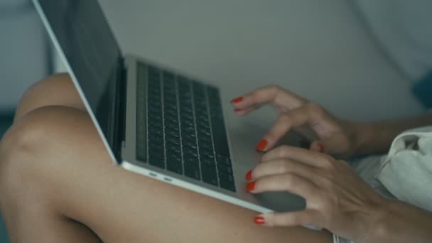 Primer plano manos femeninas con uñas de color rojo brillante están escribiendo en un ordenador portátil — Vídeo de stock