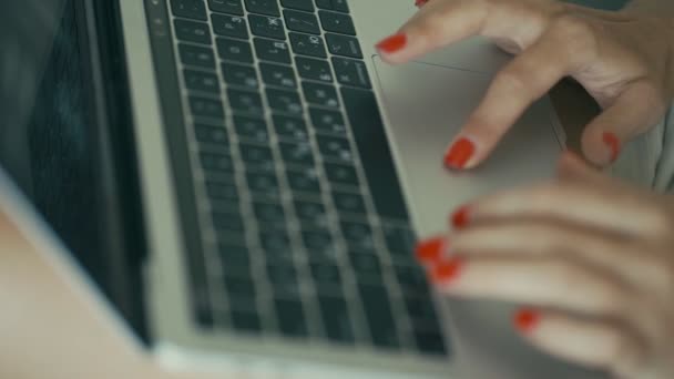 Крупним планом жіночі руки з яскраво-червоними цвяхами набирають на ноутбук — стокове відео