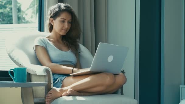 Женщина печатает на клавиатуре ноутбука из домашнего офиса — стоковое видео