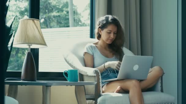 Mujer escribiendo en el teclado del ordenador portátil de la oficina en casa — Vídeo de stock